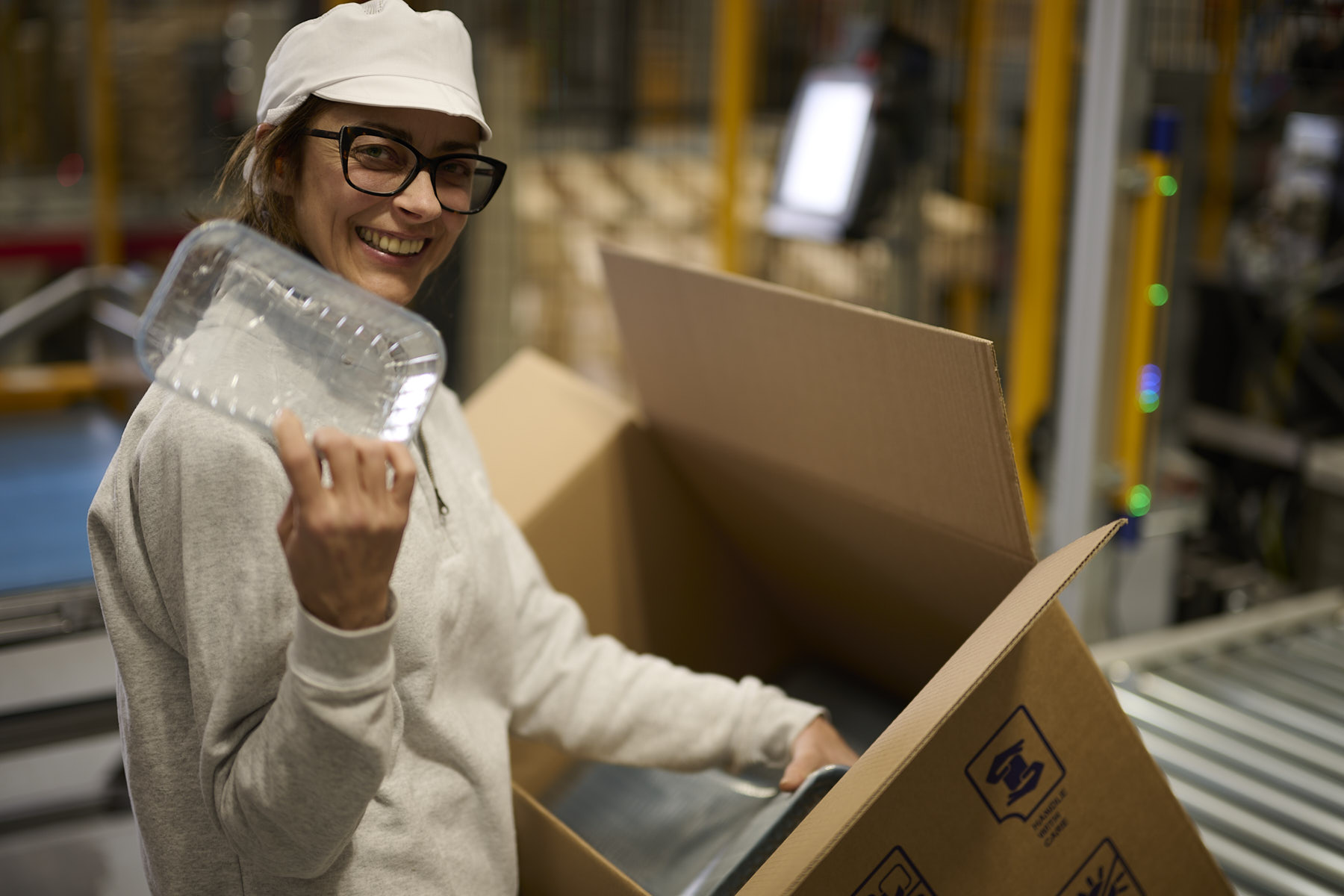 Lavoratrice sorridente con prodotto